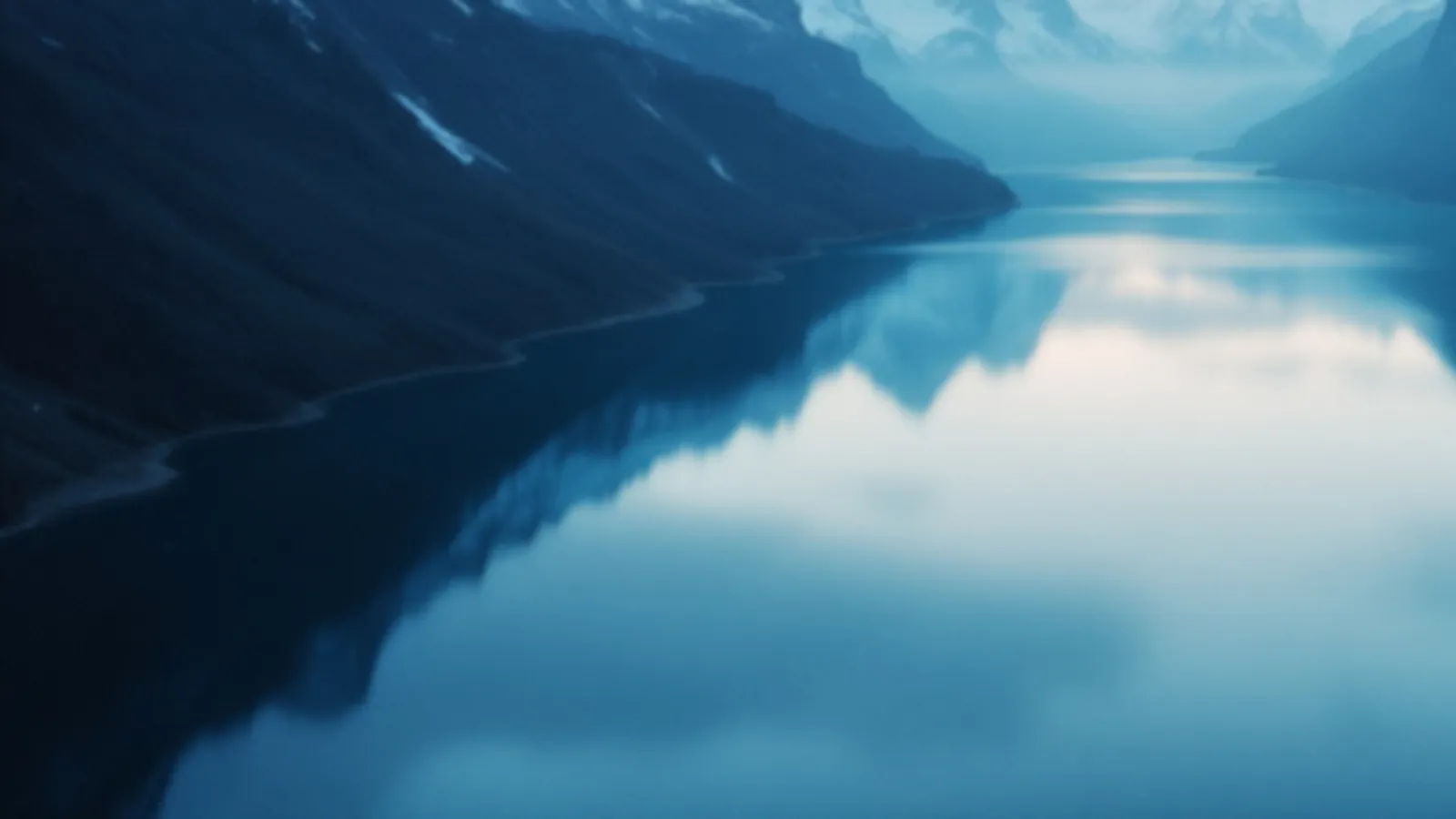 Two calm alpine lakes side by side reflecting a pale sky at dawn, the MilepostRates view of compare personal loan rates, $100 – $5,000